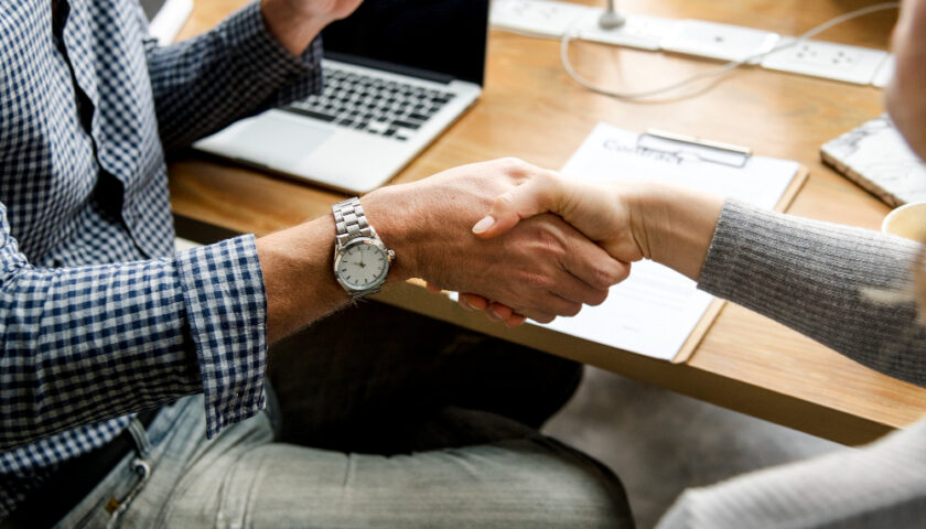 deux personnes se sert la main au bureau