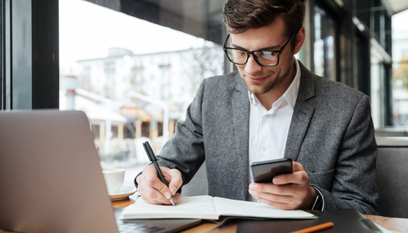 un homme d'affaire regardant son téléphone portable