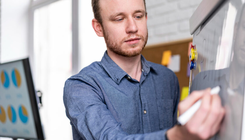 un expert comptable écrivant sur un tableau blanc